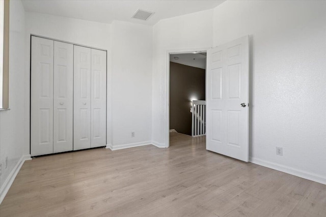 unfurnished bedroom with a closet and light wood-type flooring