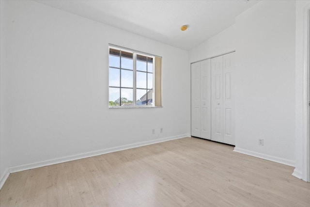 unfurnished bedroom featuring a closet and light wood-type flooring