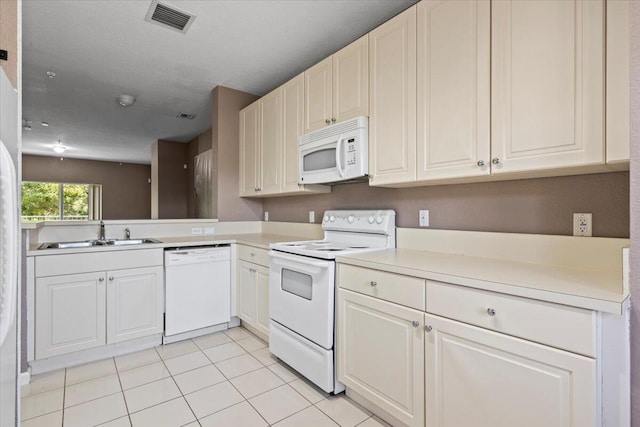 kitchen featuring white cabinets, sink, light tile patterned floors, and white appliances