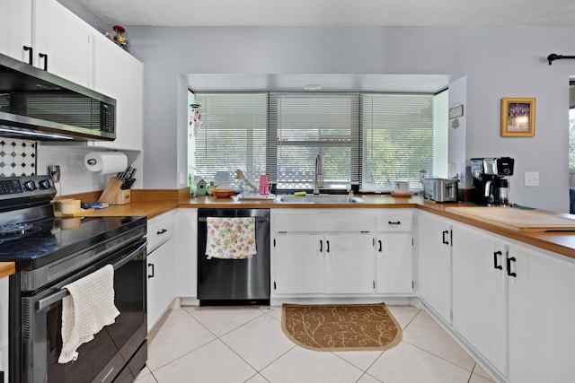 kitchen with light tile patterned flooring, electric range oven, white cabinetry, dishwasher, and sink