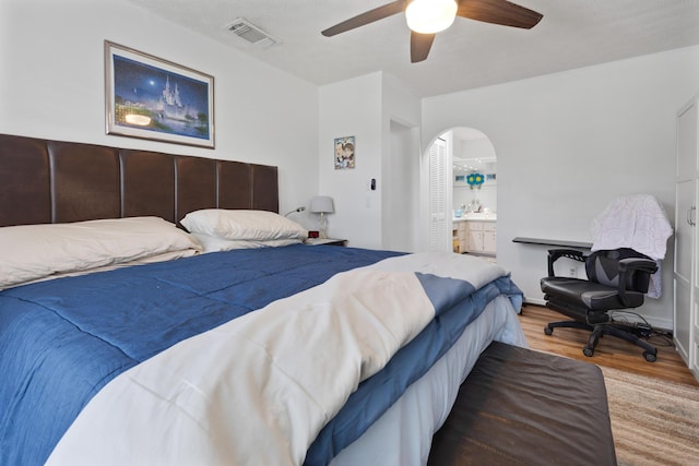 bedroom featuring ensuite bath, light hardwood / wood-style flooring, and ceiling fan