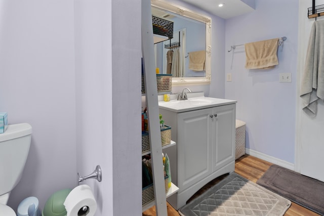 bathroom featuring vanity, hardwood / wood-style floors, and toilet