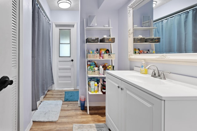 bathroom featuring vanity, hardwood / wood-style floors, and a textured ceiling