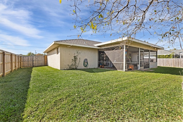 rear view of property featuring a lawn and a sunroom