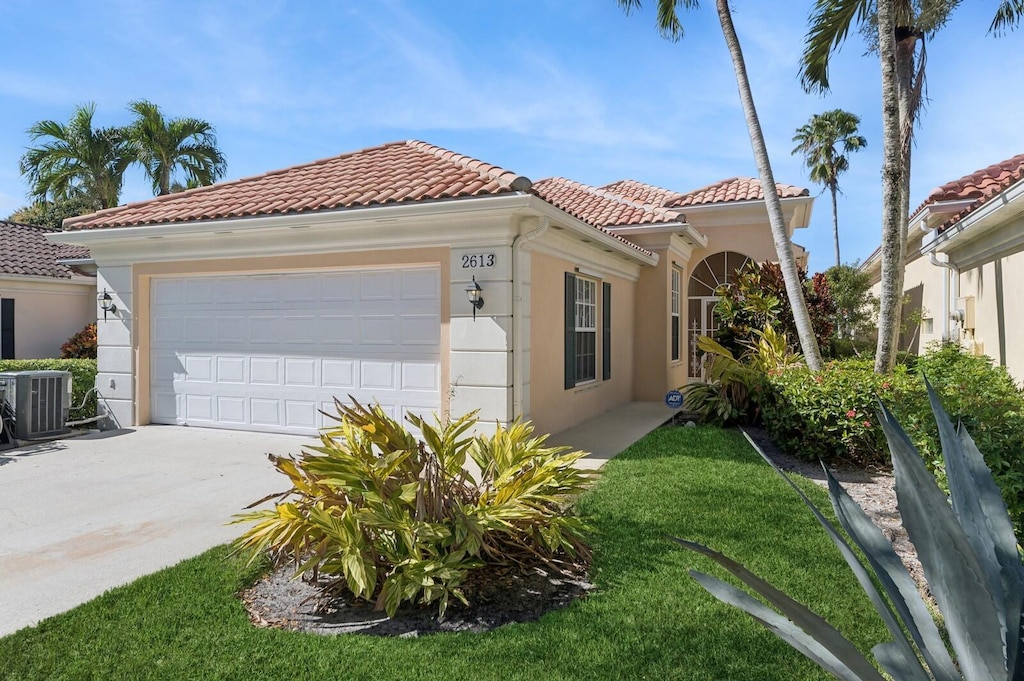 view of front of house with a garage and central AC