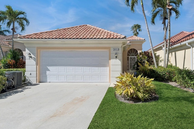 mediterranean / spanish house featuring central AC unit, a garage, and a front yard