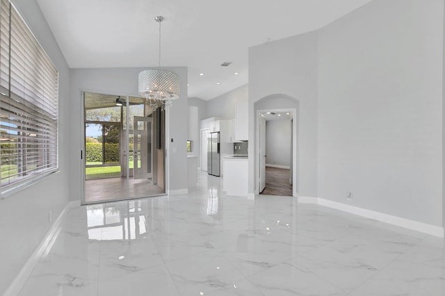 unfurnished dining area featuring ceiling fan with notable chandelier