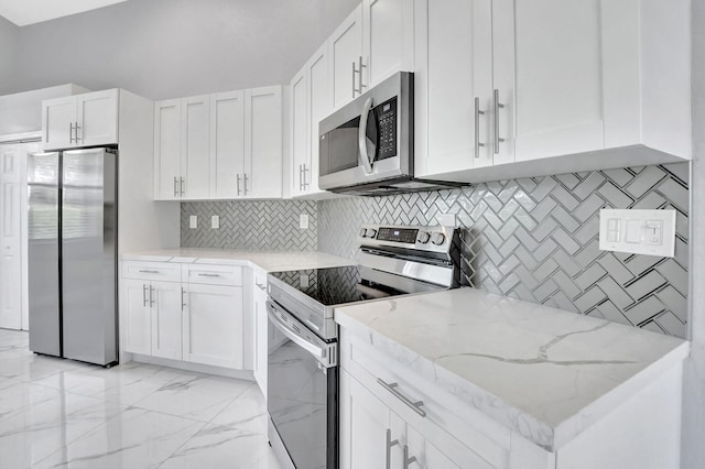 kitchen with white cabinets, appliances with stainless steel finishes, backsplash, and light stone countertops