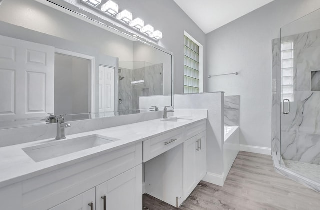 bathroom with vanity, hardwood / wood-style flooring, walk in shower, and lofted ceiling