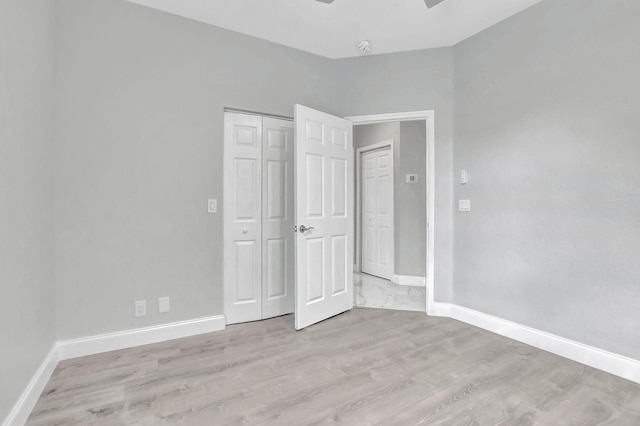 unfurnished bedroom featuring a closet and light wood-type flooring