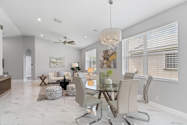 dining room with ceiling fan with notable chandelier and vaulted ceiling