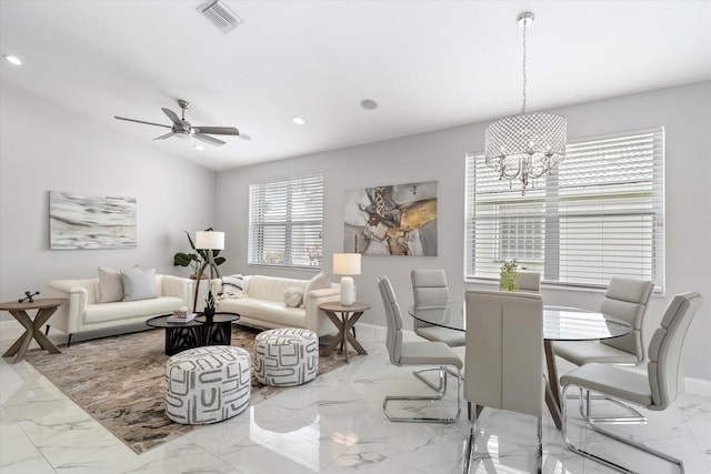 living room with vaulted ceiling, plenty of natural light, and ceiling fan with notable chandelier