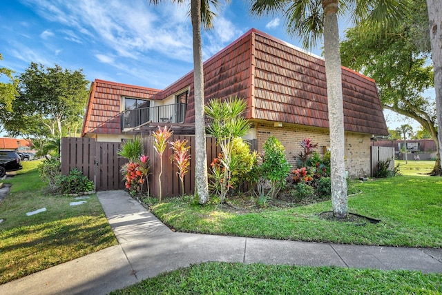 view of property exterior featuring a yard and a balcony