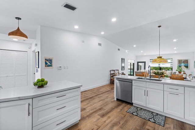 kitchen featuring hardwood / wood-style floors, dishwasher, white cabinets, sink, and hanging light fixtures