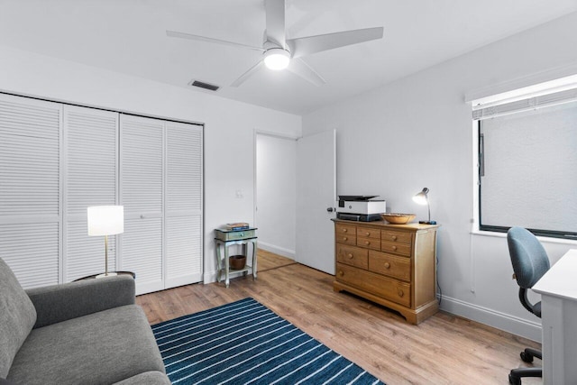 office with light hardwood / wood-style flooring and ceiling fan