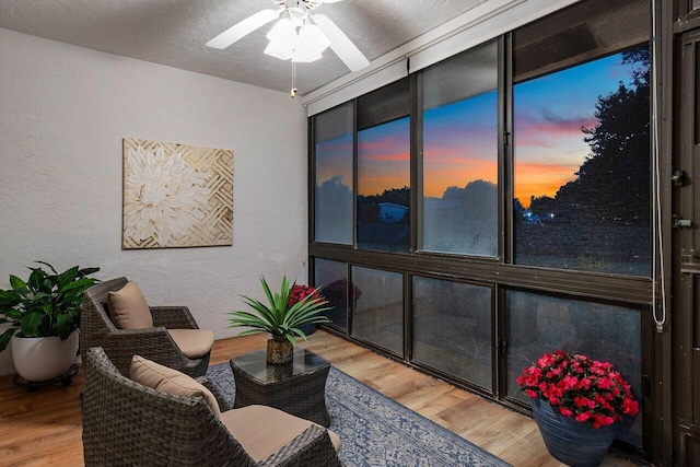 sitting room featuring wood-type flooring, a textured ceiling, and ceiling fan