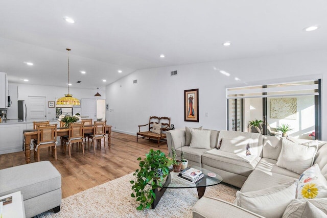 living room featuring light hardwood / wood-style floors and lofted ceiling