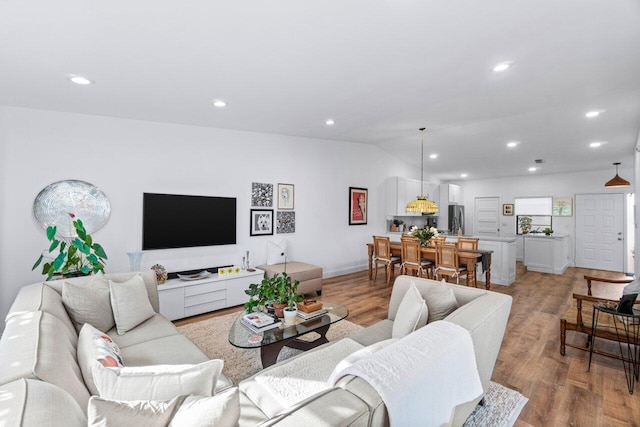 living room featuring light wood-type flooring and vaulted ceiling