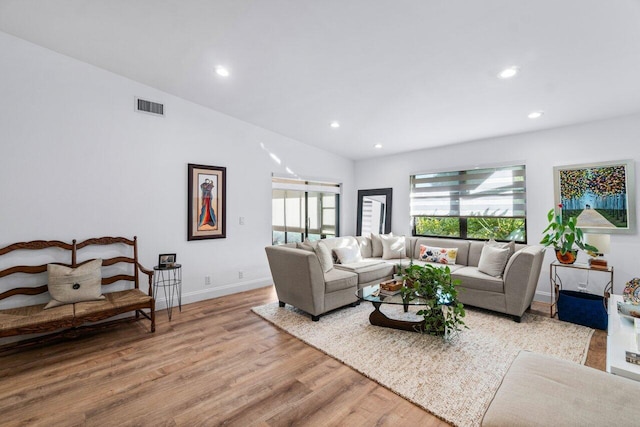 living room with light hardwood / wood-style flooring and vaulted ceiling