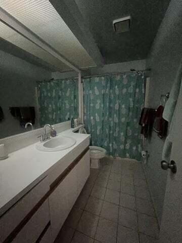 bathroom featuring vanity, a shower with shower curtain, and toilet