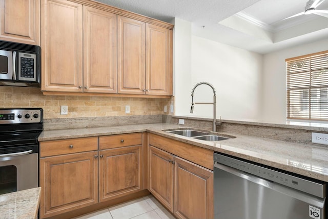 kitchen featuring crown molding, sink, light stone countertops, and stainless steel appliances