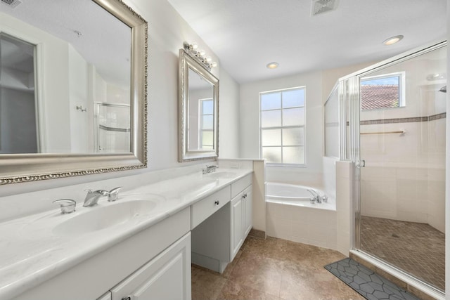 bathroom featuring plus walk in shower, vanity, and tile patterned floors