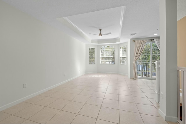 tiled spare room with a raised ceiling, ceiling fan, and a textured ceiling