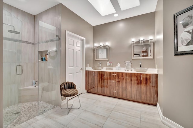 bathroom featuring tile patterned floors, vanity, a shower with door, and a skylight