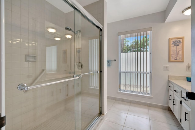 bathroom featuring vanity, walk in shower, and tile patterned flooring