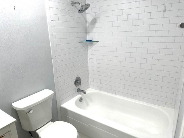 full bathroom featuring tiled shower / bath, vanity, and toilet