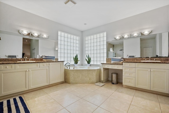 bathroom featuring tiled bath, tile patterned flooring, and vanity