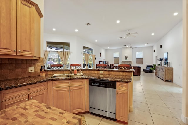 kitchen with stainless steel dishwasher, dark stone counters, ceiling fan, sink, and light tile patterned floors