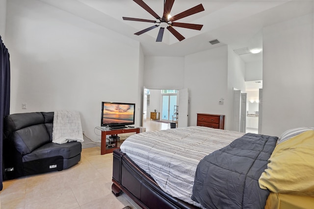 tiled bedroom featuring ceiling fan and ensuite bath