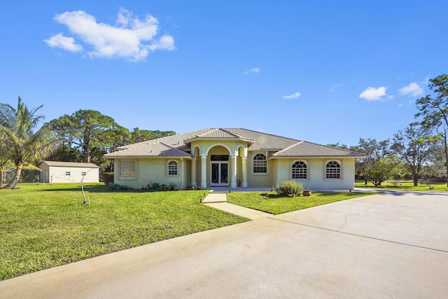 mediterranean / spanish-style house with a front yard and a shed