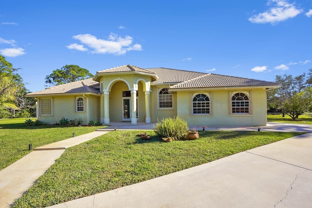 mediterranean / spanish home with a front lawn