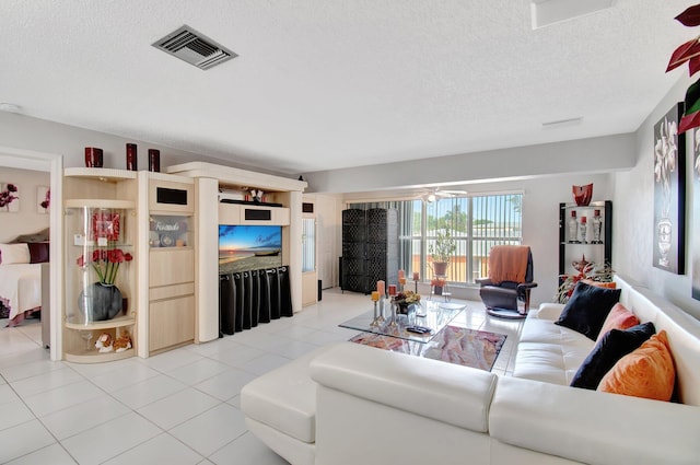 tiled living room featuring ceiling fan and a textured ceiling