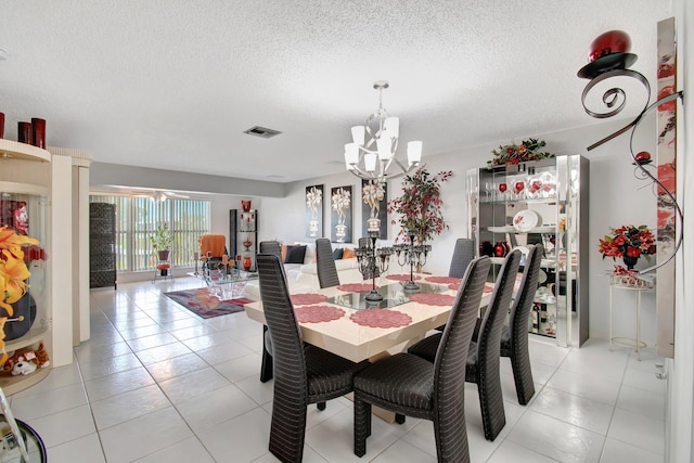 tiled dining area with a notable chandelier and a textured ceiling