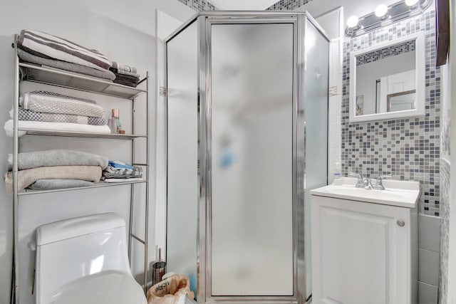 bathroom featuring backsplash, vanity, a shower with door, tile walls, and toilet