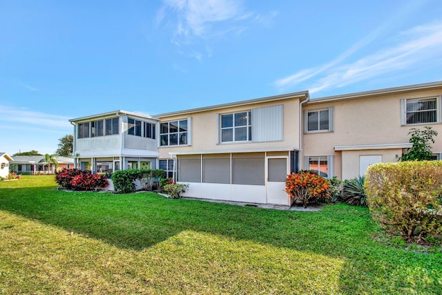 back of property featuring a sunroom and a yard