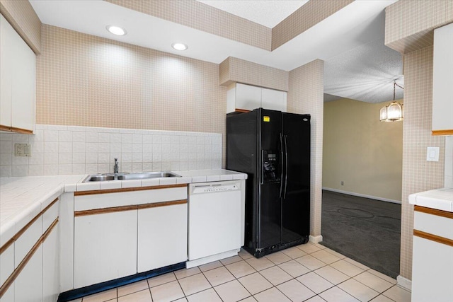 kitchen featuring white dishwasher, white cabinetry, sink, and black refrigerator with ice dispenser