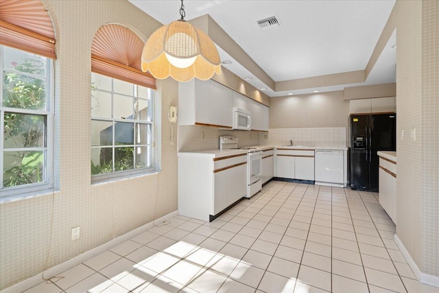 kitchen featuring decorative backsplash, white appliances, light tile patterned floors, white cabinets, and hanging light fixtures