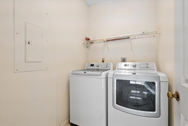 clothes washing area with separate washer and dryer and electric panel