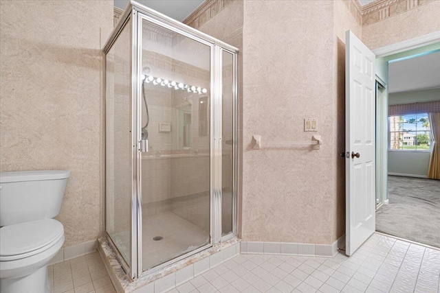 bathroom with tile patterned flooring, toilet, and an enclosed shower