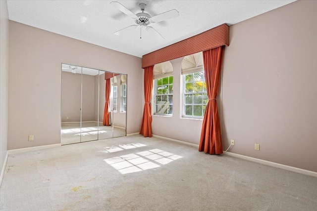 unfurnished bedroom featuring ceiling fan, a closet, and light carpet