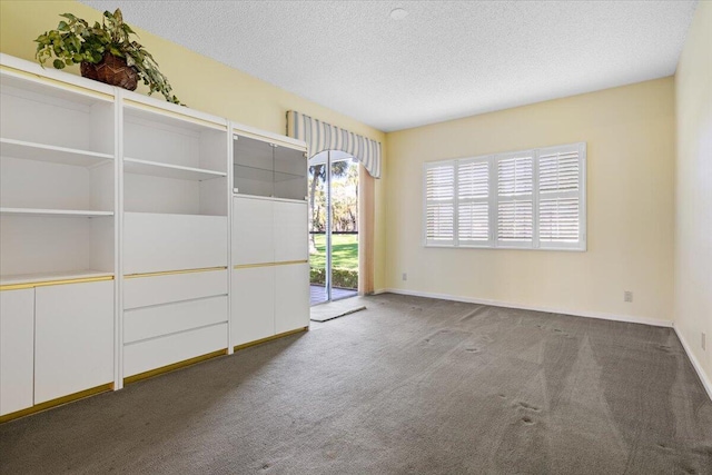 carpeted empty room with a textured ceiling