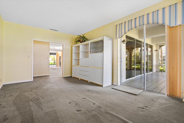 carpeted spare room with a textured ceiling