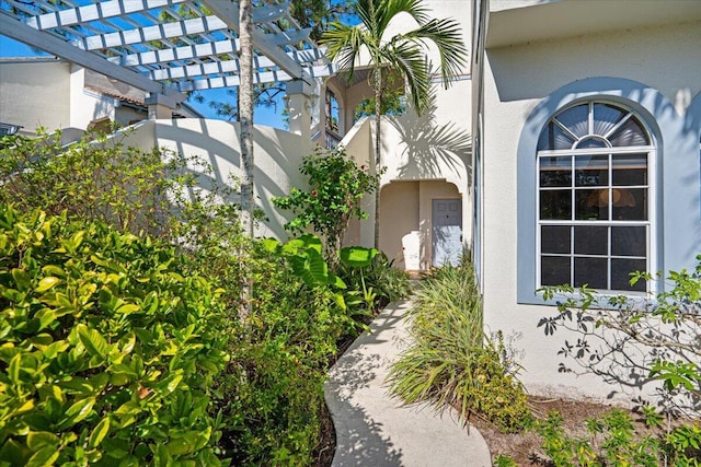 doorway to property with a pergola