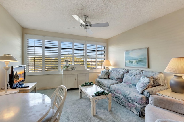 living room featuring light carpet, a textured ceiling, and ceiling fan