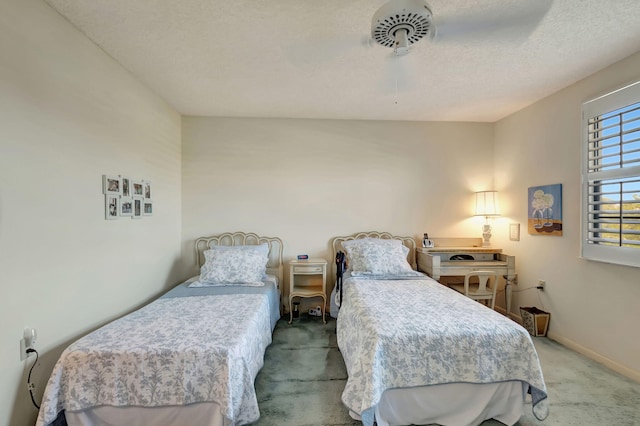 bedroom with ceiling fan, light colored carpet, and a textured ceiling