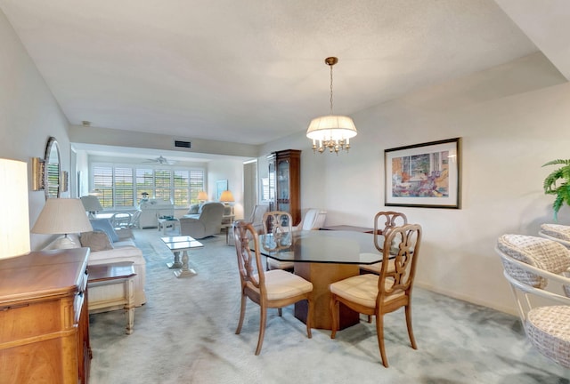 dining area with ceiling fan with notable chandelier and light colored carpet